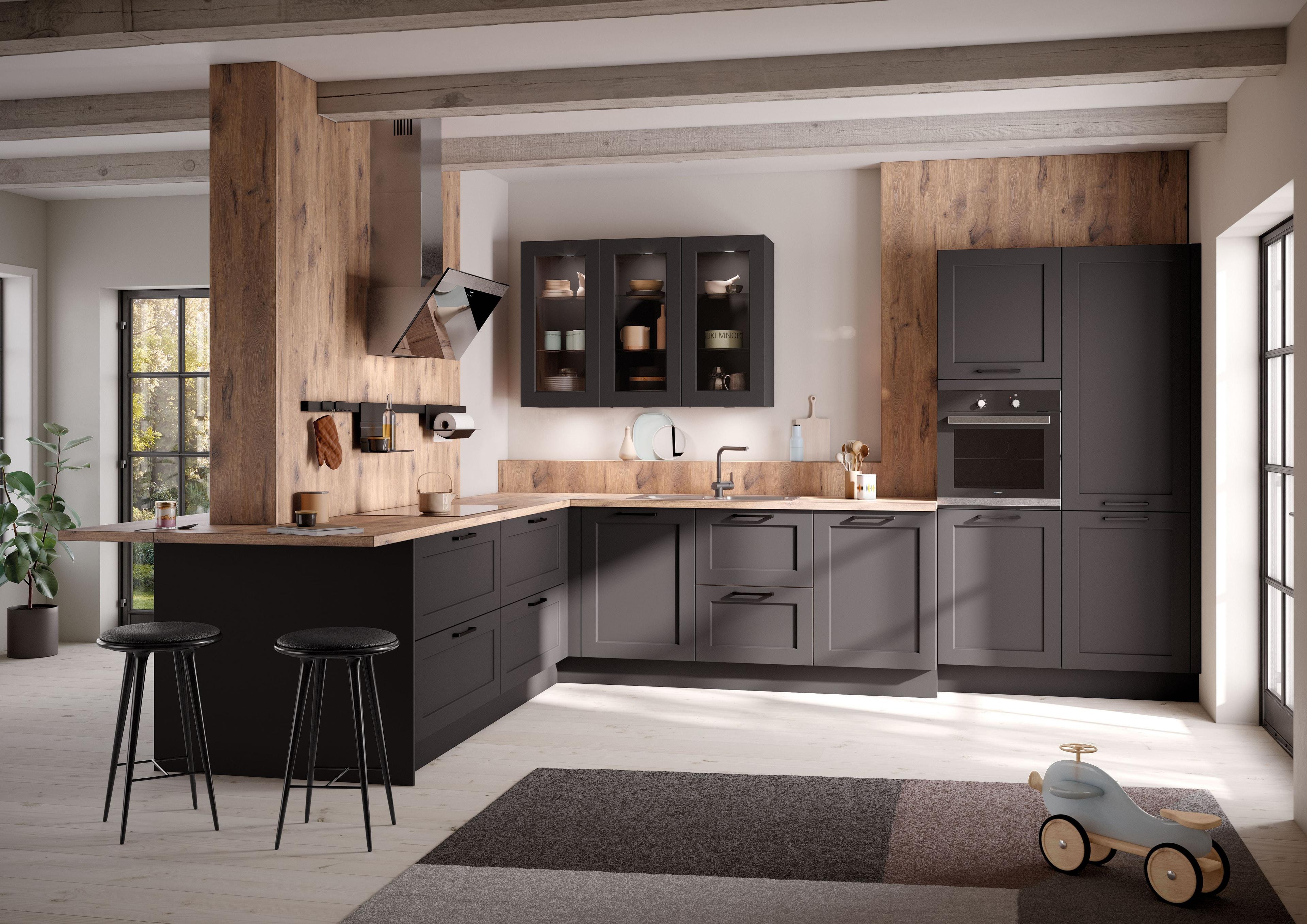 Elegante Landhausküche in mattem Schwarz mit Holzelementen und Vitrinenschränken von Häcker.