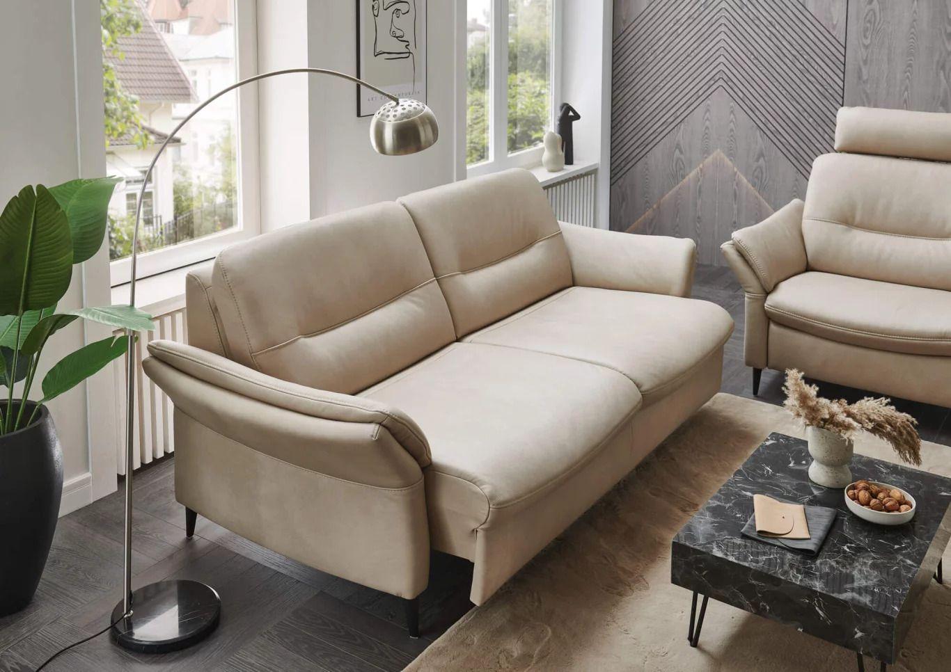 Beiges Hukla Sofa mit weicher Polsterung und modernem Design in stilvollem, hellen Wohnzimmerambiente.