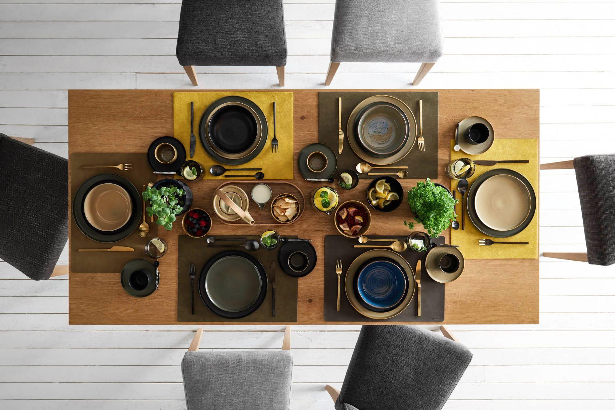 Klose Catera Esstisch in Eiche mit sechs grauen Polsterstühlen aus der Vogelperspektive, stilvoll gedeckt mit Geschirr und Platzsets in Erdtönen auf weißem Holzboden