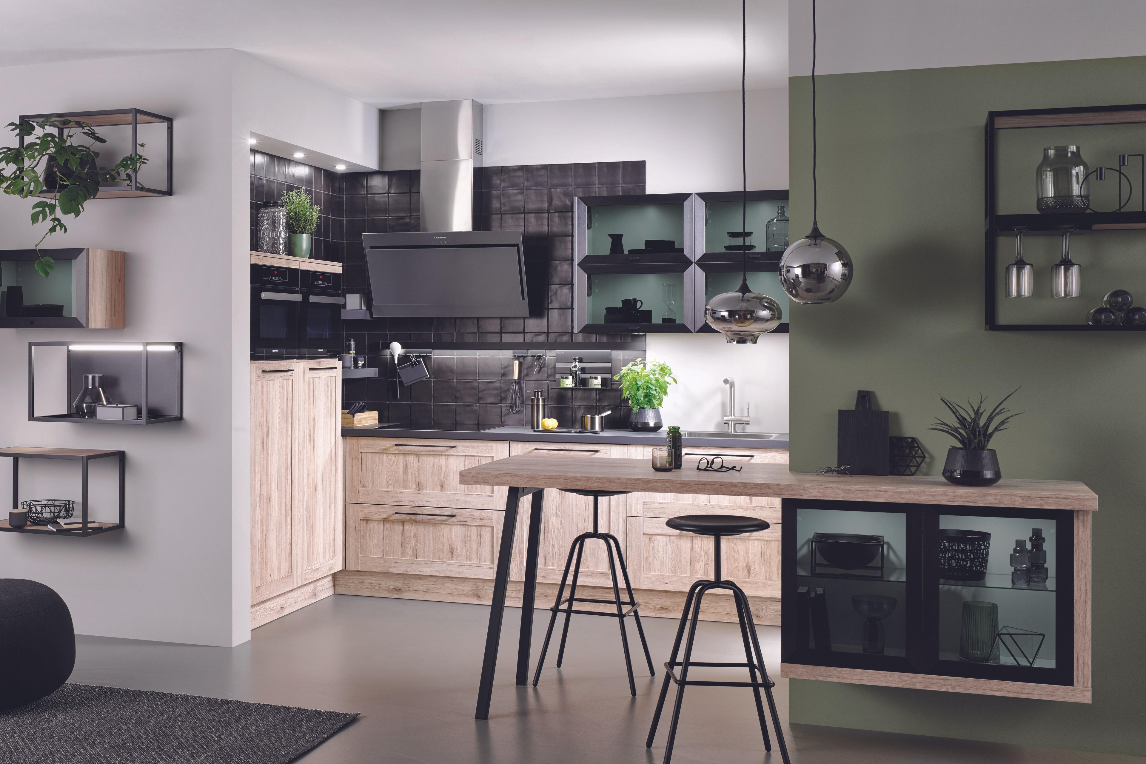 Offene Designküche in heller Eichenoptik mit schwarzen Fliesenspiegeln und Industrial-Details.