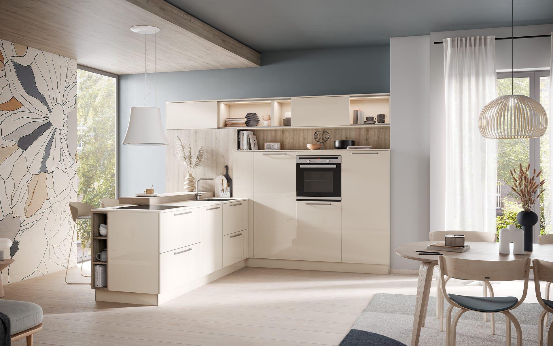 Häcker Küche Laser Brillant in Crema/Magnolie – helle L-Planung mit Eckspüle, Backofenhochschrank, offenen und beleuchteten Regalen sowie Holzrückwand in einem wohnlichen Essbereich mit großem Fenster