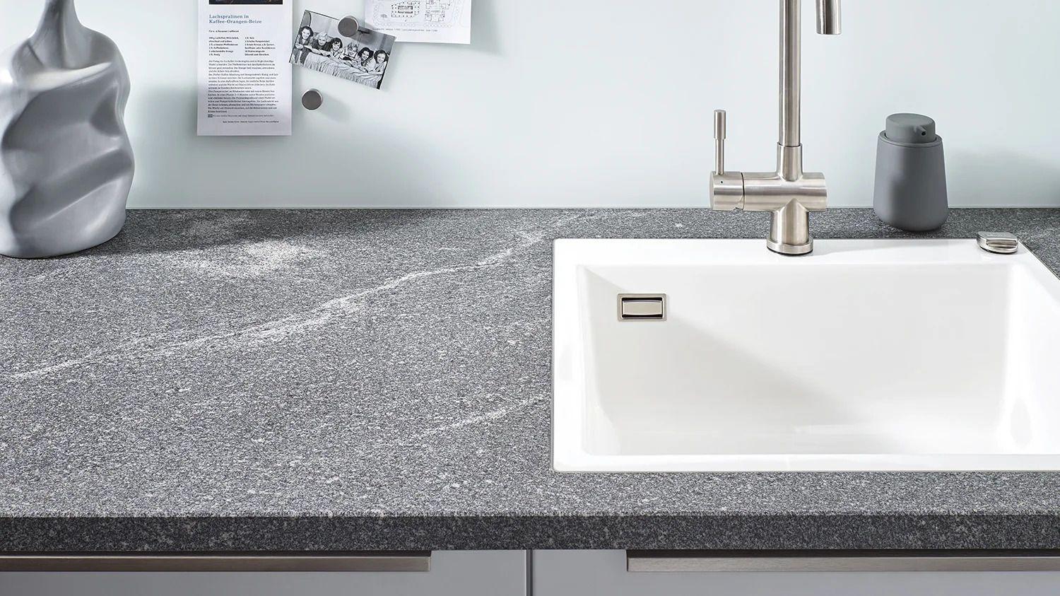 Lechner Arbeitsplatte aus Naturstein Elegant Grey mit strukturierter Oberfläche und weißem Spülbecken.